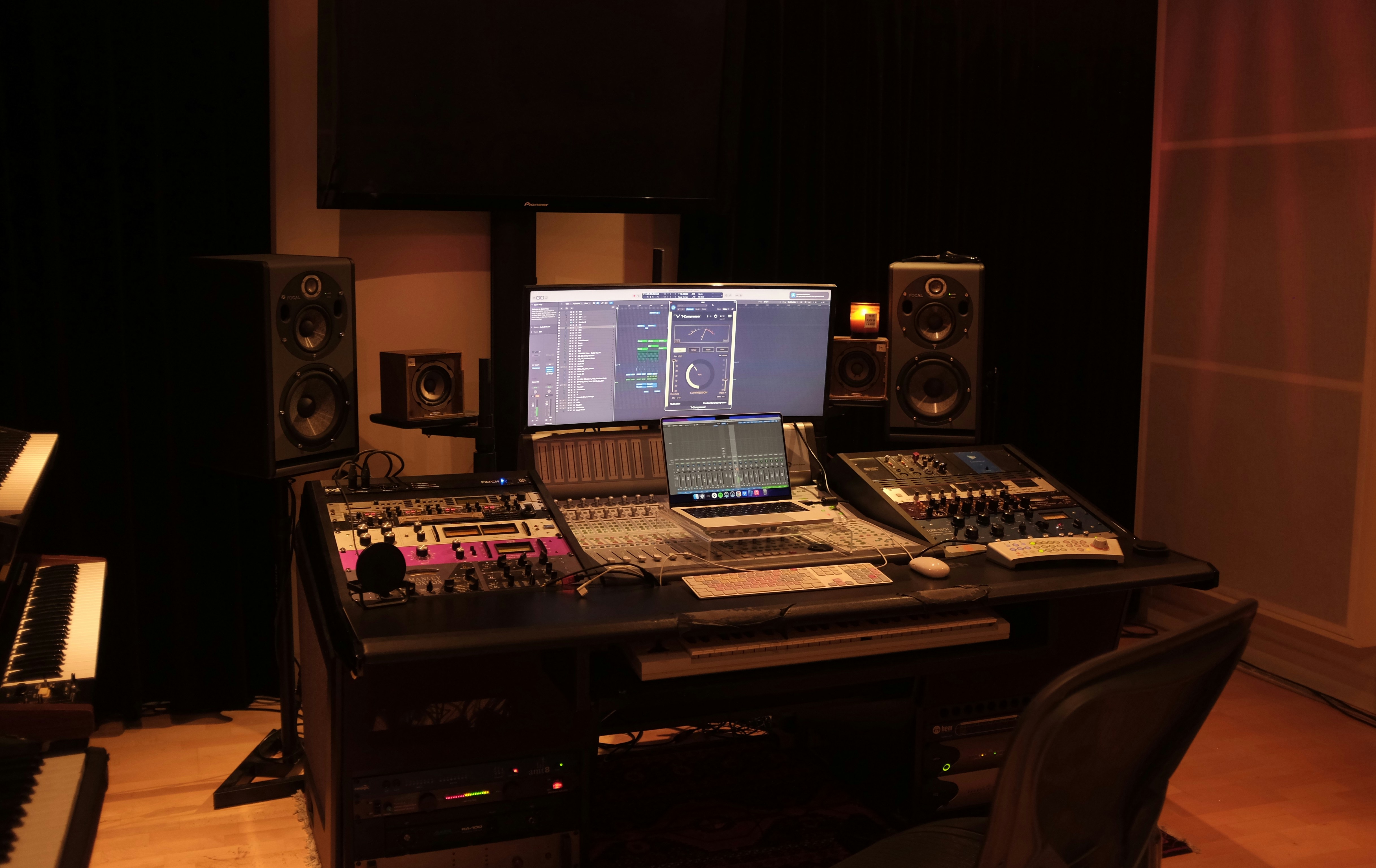 A music producer at a professional mixing desk in a recording studio